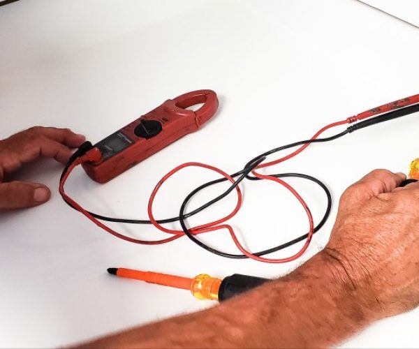 electrician-is-testing-outlet-to-check-amount-of-power-with-his-tools-and-equipment-in-hand_t20_a79Z7v